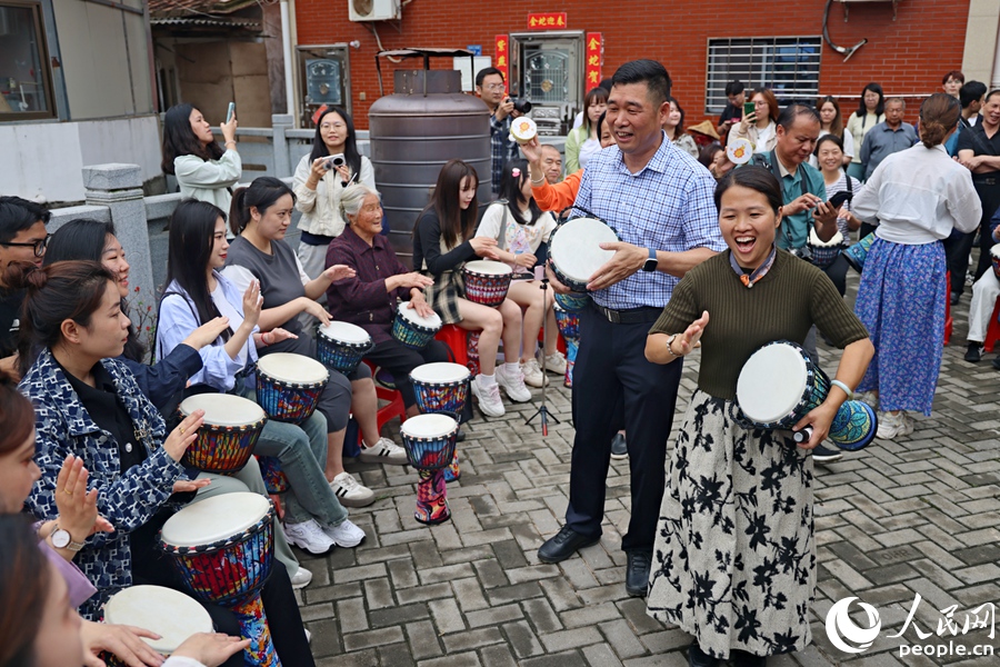 在“爱拼食堂”参与手鼓演奏。人民网记者 陈博摄